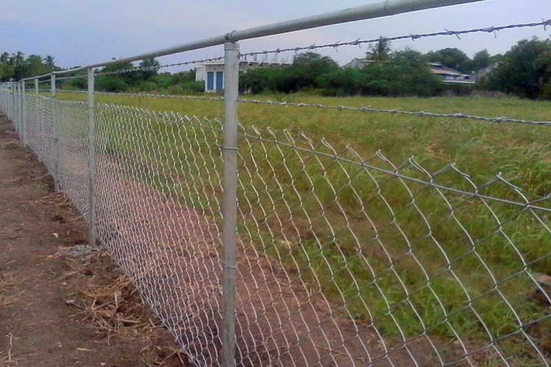 Recinzione di confine dell'azienda agricola con filo spinato
